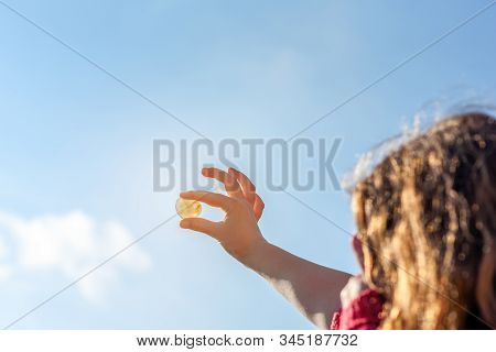 Heart Shaped Stone Held In Hands, Blue Sky In Background. Rockhounding Displays A Stone That Allows 