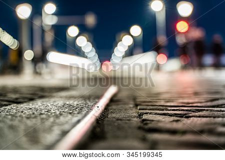 Blurred Background Of A Bridge And Sharpness In Paving Of A Shopping City With Bokeh City Lights