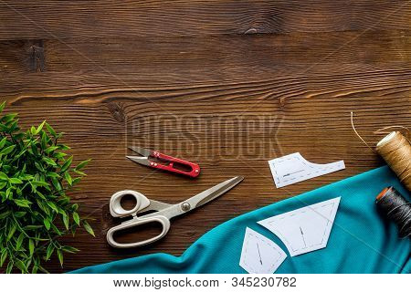 Sewing Wokrshop. Textile, Pattern, Scissors, Thread On Dark Wooden Background Top-down Copy Space