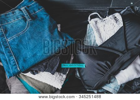 Luggage With Pile Of Clothes And Packing Everything Label On Them