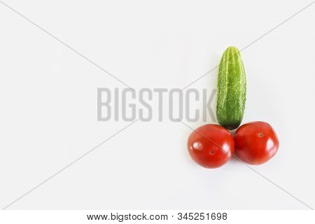 Red Ripe Juicy Tomatoes And Green Cucumber. The Phallic Image Of Natural Components. Light Gray Back