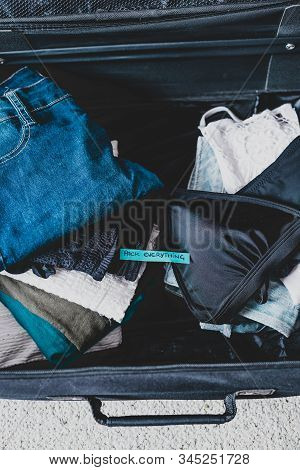 Luggage With Pile Of Clothes And Packing Everything Label On Them