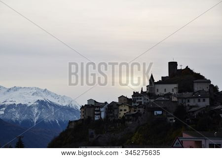 Village Of Saillon In Switzerland With Snowy Mountains Behind