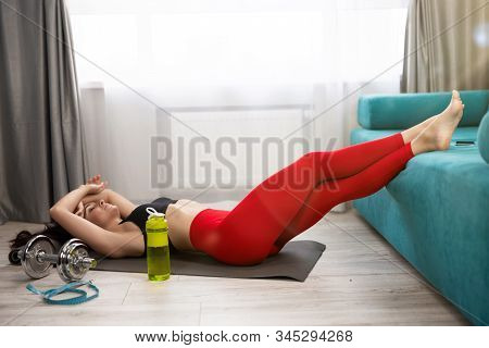 Young Fit Beautiful Woman In Sportwear Lies On The Floor Looking Tired After Daily Home Workout On T