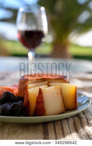 Tastes Of Spain, Jamon Iberian, Black Olives, Manchego Cheese With Red Paprika And Glass With Red Ri