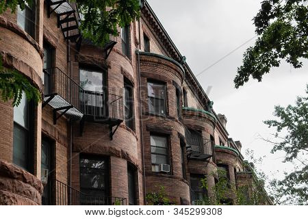 View Looking Down A Row Of Old Brownstone Apartment Buildings With Half Round Fronts, Metal Baconies