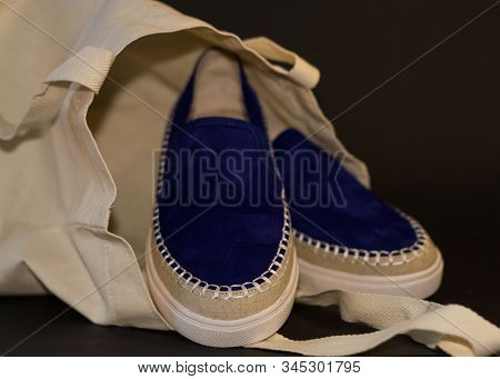 On Black Background Of The Shopping Bag, Shopper, Of Beige Cloth And Blue Slipons Of Suede. Street F