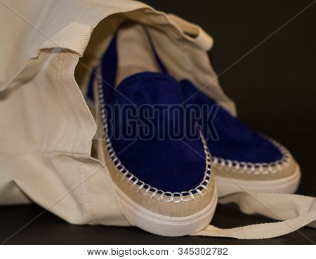 On Black Background Of The Shopping Bag, Shopper, Of Beige Cloth And Blue Slipons Of Suede. Street F