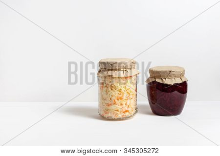 Homemade Sauerkraut With Carrots And Cabbage Salad With Beets In A Glass Jar On A White Wooden Backg