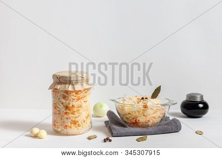 Homemade Sauerkraut With Carrots In A Glass Jar And Bowl On A White Wooden Background. Fermented Foo