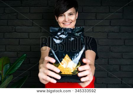 Beautician Hold Ransparent Packet Of Seal Wax Beads. Bright Colored Granules. Wooden Background.pear