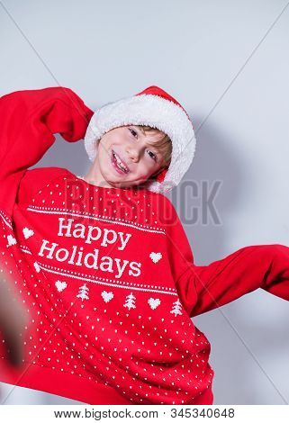 Charming Boy Wearing Santa's Hat In Red Sweater