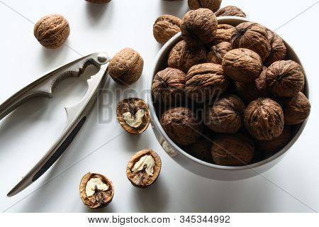 Inshell Walnuts In A White Bowl On A White Table