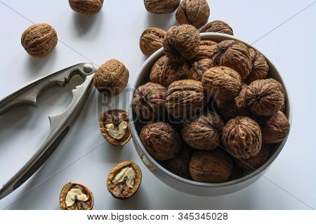Inshell Walnuts In A White Bowl On A White Table