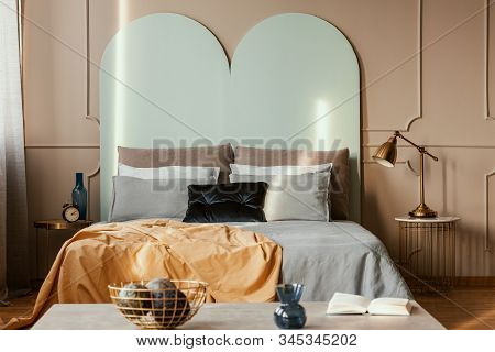 Knick Knacks On Console Table In From Of King Size Bed With Comfortable Bedding