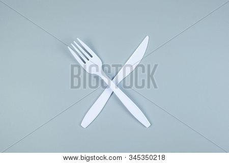 White Plastic Fork And Knife On Gray Background With Copy Space For Text. Environmental Protection, 
