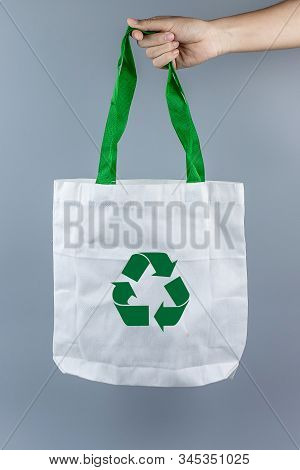 Man Holding Eco Shopping Bag On Gray Background With Copy Space For Text. Environmental Protection, 