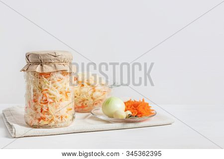 Homemade Sauerkraut With Carrots In A Glass Jar And Bowl On A White Wooden Background. Fermented Foo