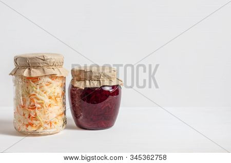 Homemade Sauerkraut With Carrots And Cabbage Salad With Beets In A Glass Jar On A White Wooden Backg