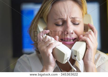 Face Of Office Woman In Stress With A Lot Of Phone Calls At Same Time. Unhappy Woman Holds Two Hands