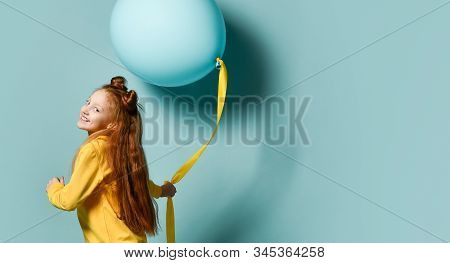 Red-headed Teenage Girl With Fancy Hairstyle In Yellow Sweatshirt Holding Balloon, Posing Sideways O