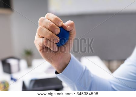 Close-up Of Person Hand Holding Blue Stressball