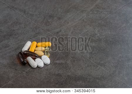 Collection Of Various Vitamins In Both Pills And Gelcap On Black Textured Background.