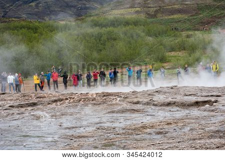 Tourists Visiting Strokkur Geyser In Iceland