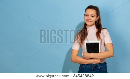 Showing Tablet Screen. Caucasian Teen Girls Portrait On Blue Background. Beautiful Model In Casual. 