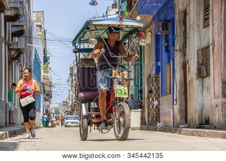 Havana, Cuba - May 16, 2019: Bicycle Taxi Driver In The Street Of Old Havana City During A Vibrant A