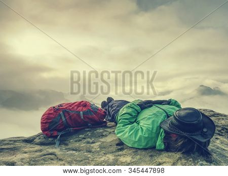 Hiker Woman In Hat Lying On Stone And Relaxing In Mountains. Alone Hipster Girl On Top Of Mountain, 