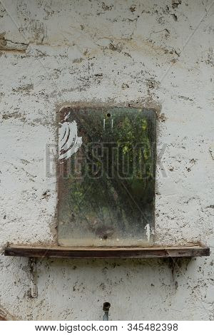 Vintage Rusty Glass Mirror On Old Textured Wall.