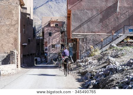 Imlil, Morocco - January 7, 2020: Berber Man Riding A Horse In Mountainous Village In Atlas
