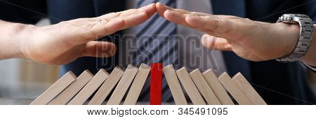 Close-up View Of Businessmans Hands Protecting Line Of Wooden Blocks. Colourless Bricks With One Red
