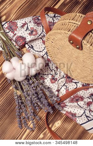 Round Straw Bag, Female Silk Scarf And Bouquet Of Lavender And Cotton Flowers. Spring Girl Fashion O