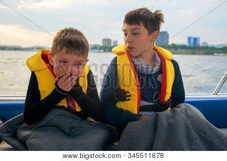 Boy Suffers From Seasickness On Board The Boat, Closes His Mouth With His Hands