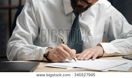 Close-up Of A Businessman Writing Or Signing Document