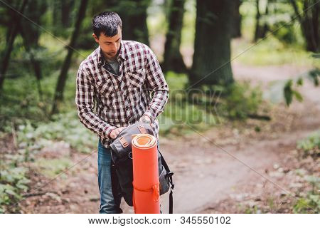 Hiker Holding His Camping Backpack. Traveler Opening Backpack While Traveling In Beautiful Wood. The