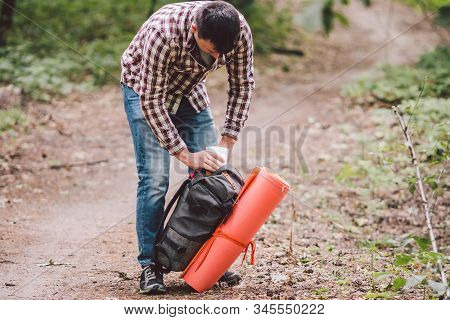 Hiker Holding His Camping Backpack. Traveler Opening Backpack While Traveling In Beautiful Wood. The