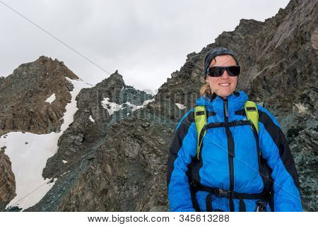 Portrait Of Female Mountaineer Posing In The Mountains.