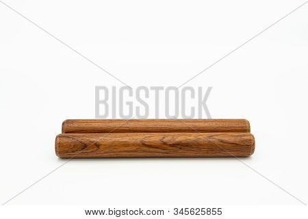 Closeup Of A Pair Of Wooden Claves Lying On A White Underground