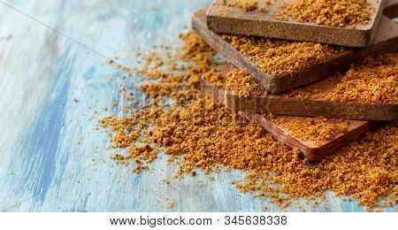 Brown Unrefined Cane Sugar On A Blue Wooden Table Close Up