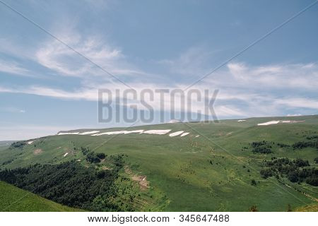 Summer View Of The Plateau Lago Naki With Snow. Beautiful Clouds And Mountain In A Blue Haze.