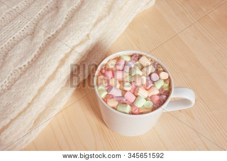 Hot Chocolate Beverage With Colorful Marshmallows On Light Wooden Background With White Fluffy Knitt