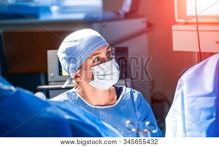 Handsome Surgeon In Medical Mask And Scrubs Is Looking Away