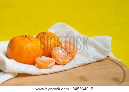 Mandarin And Slices Of Citrus On A Yellow Background. Orange Mandarin Or Tangerine Natural Fruit.