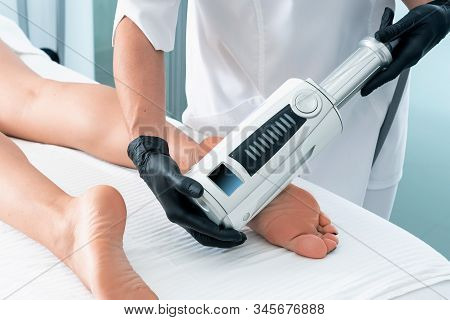 Cosmetologist In Rubber Gloves Doing Endospheres Therapy On Female Feet
