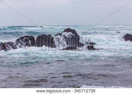 Beautiful Nature Scene Of Sea Wave Hitting On The Black Stone Shoreline At Jeju Island, South Korea.