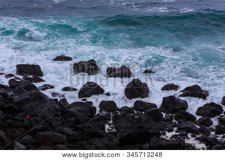 Beautiful Nature Scene Of Sea Wave Hitting On The Black Stone Shoreline At Jeju Island, South Korea.
