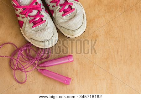 Sport Sneakers Background. Modern Sneakers And Jump Ropy On Wooden Background. Flat Lay. Copy Space.